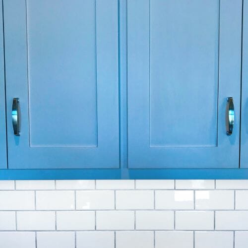 Blue cabinet and white subway tile in a kitchen.