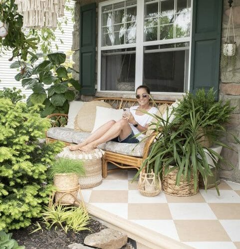 Lady sitting on a front porch surrounded by plants in Deltona Fl.